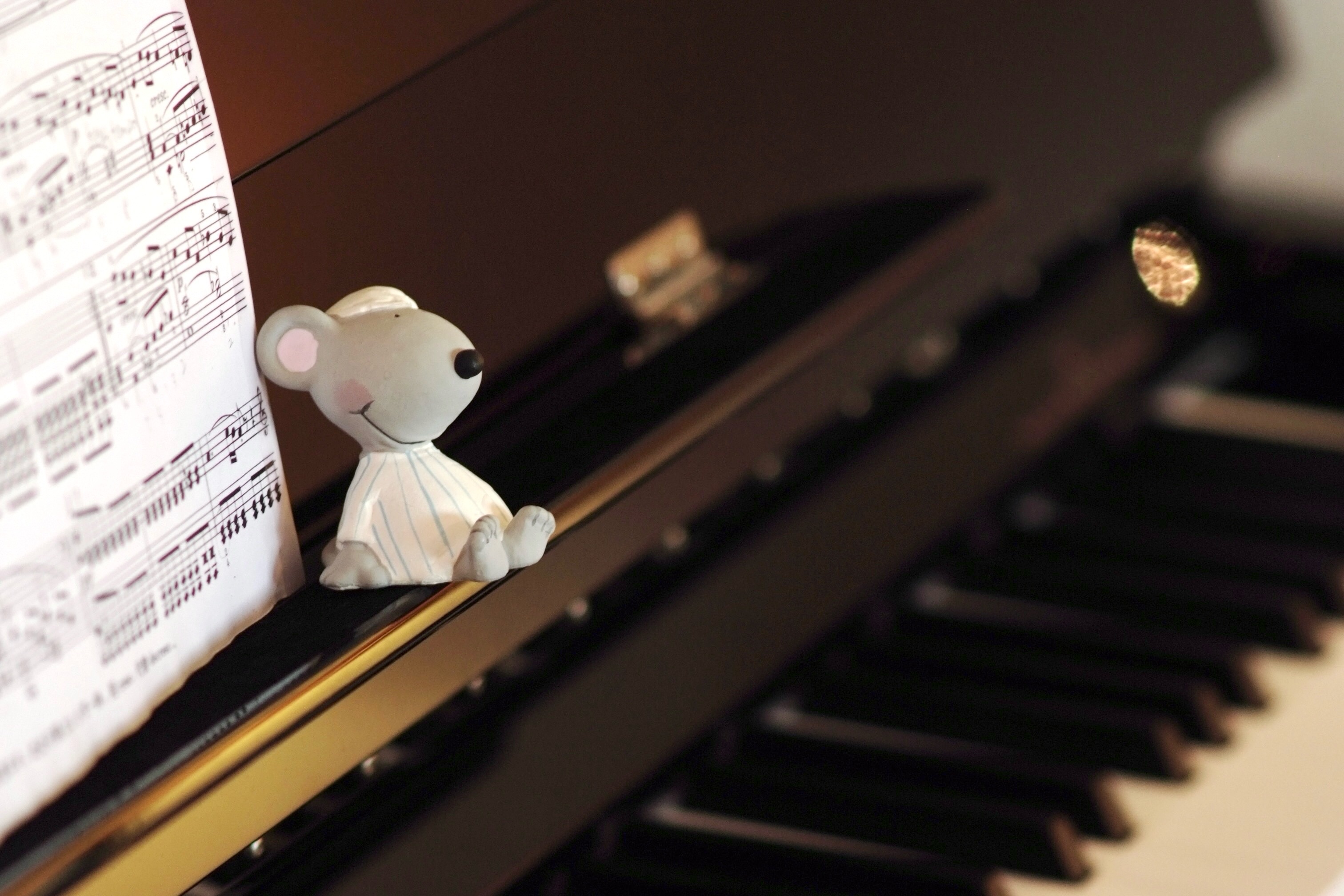 Piano, sheet music, and a small figure in a warm lesson atmosphere